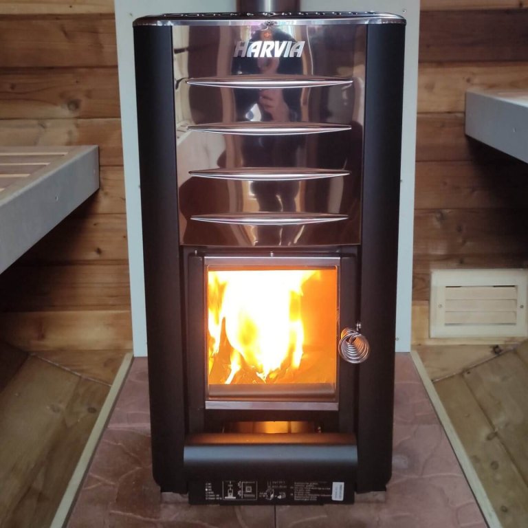 Sauna Innenraum mit Harvia Holzofen und loderndem Feuer