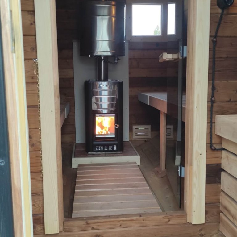 Sauna Innenraum und Vorraum mit Harvia Holzofen und loderndem Feuer