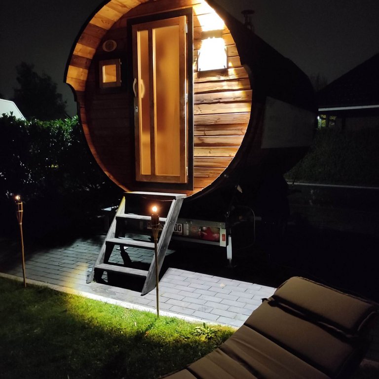 Sauna bei Nacht mit Fackeln und Wellness-Liegen